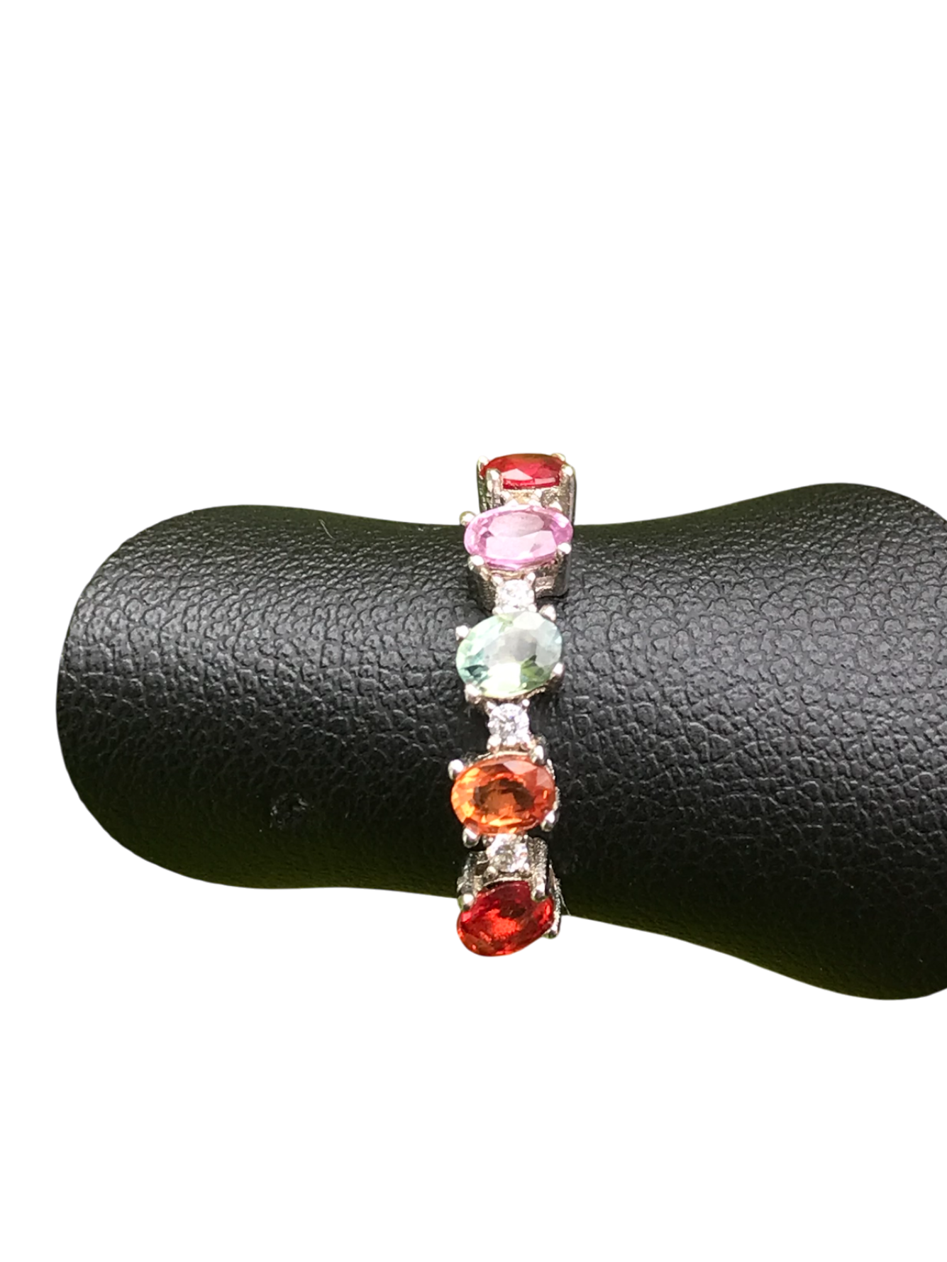 Multicolored gemstone ring on a black jewelry display
