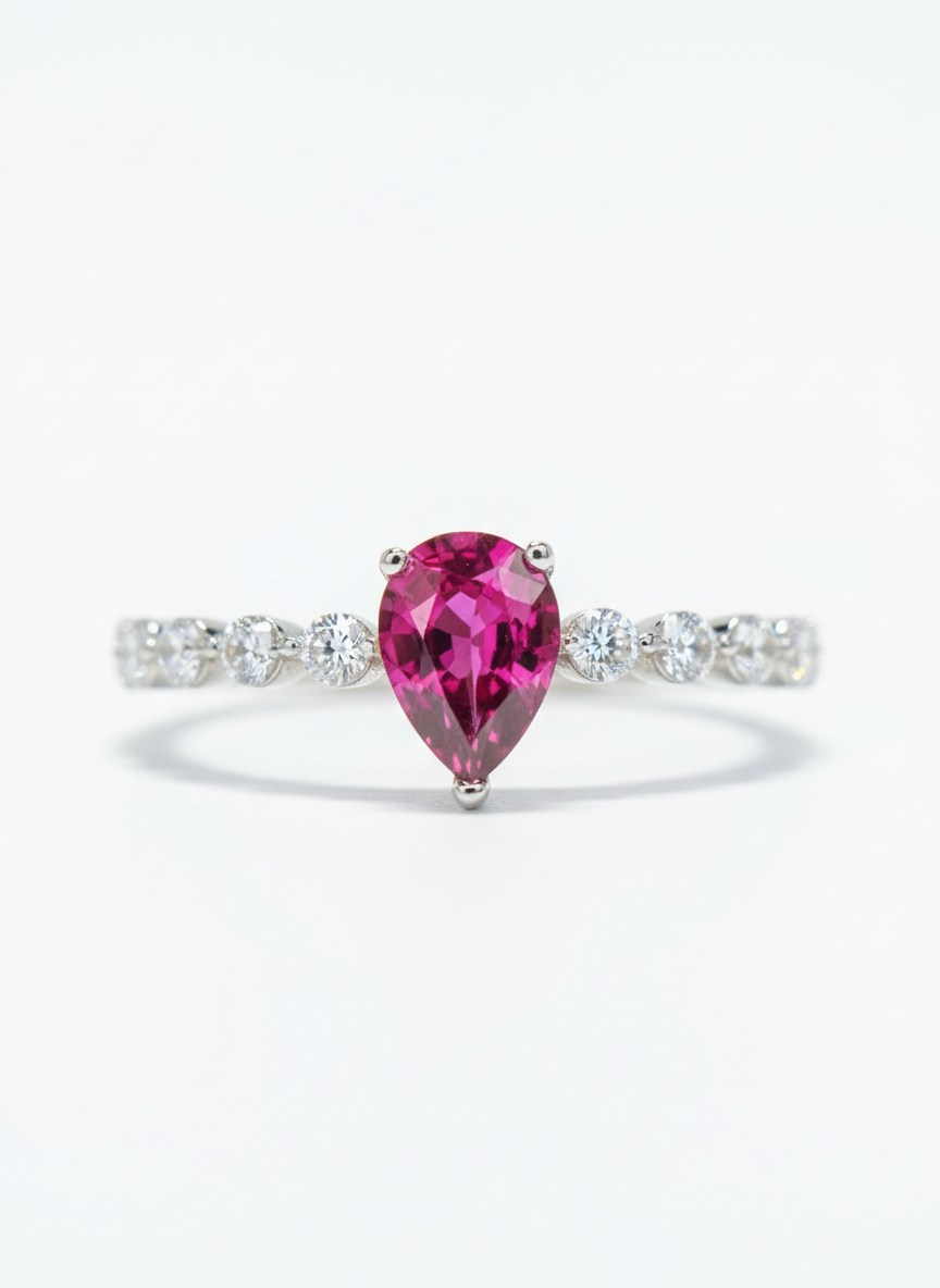 Ring with a pink gemstone and diamond-studded band on a white background