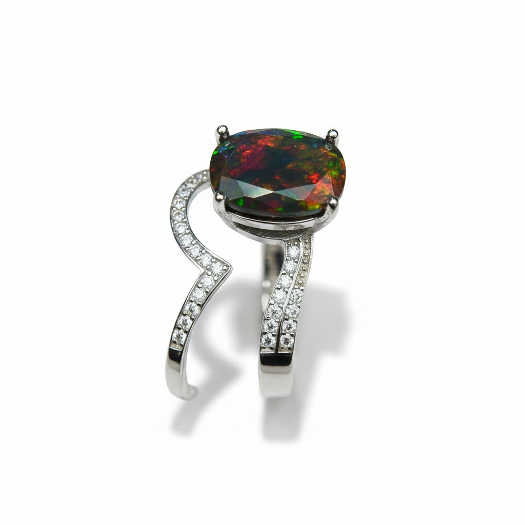 Ring with a colorful gemstone and diamond-studded band on a white background