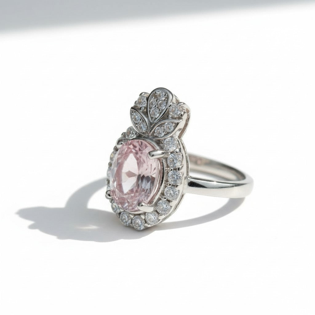 Silver ring with a pink gemstone and diamond accents on a white background