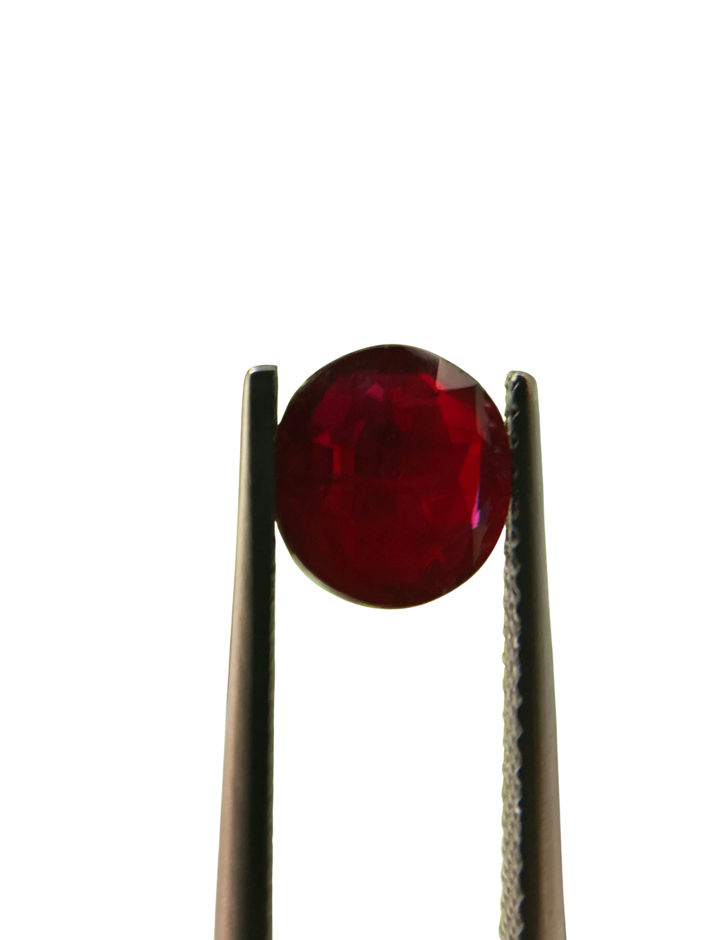 Shiza Gems 2.04 ct round cut vivid red unheated natural ruby gemstone held by tweezers.