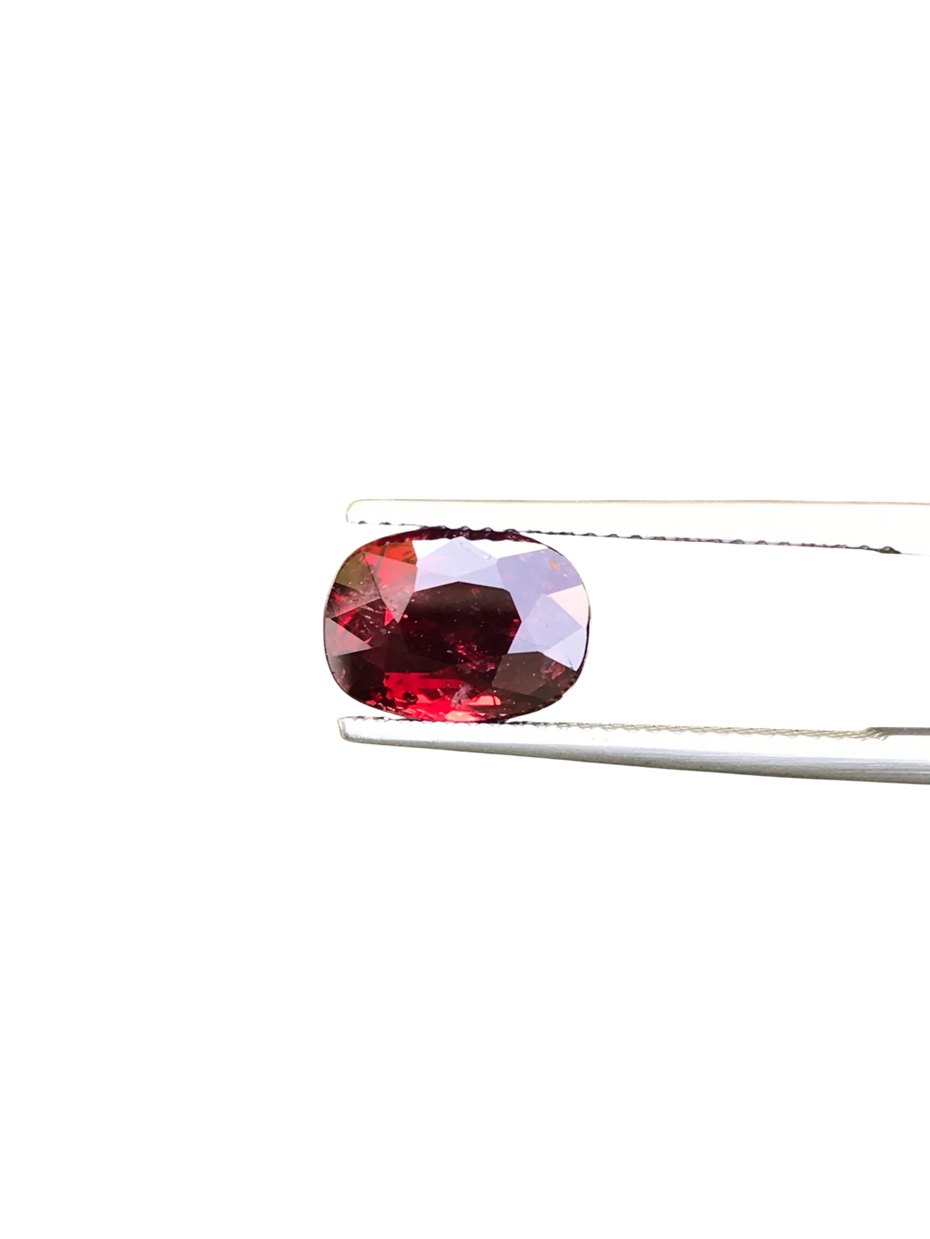 Shiza Gems 3.06 ct oval cut vivid red unheated natural ruby gemstone held by tweezers against a black background.