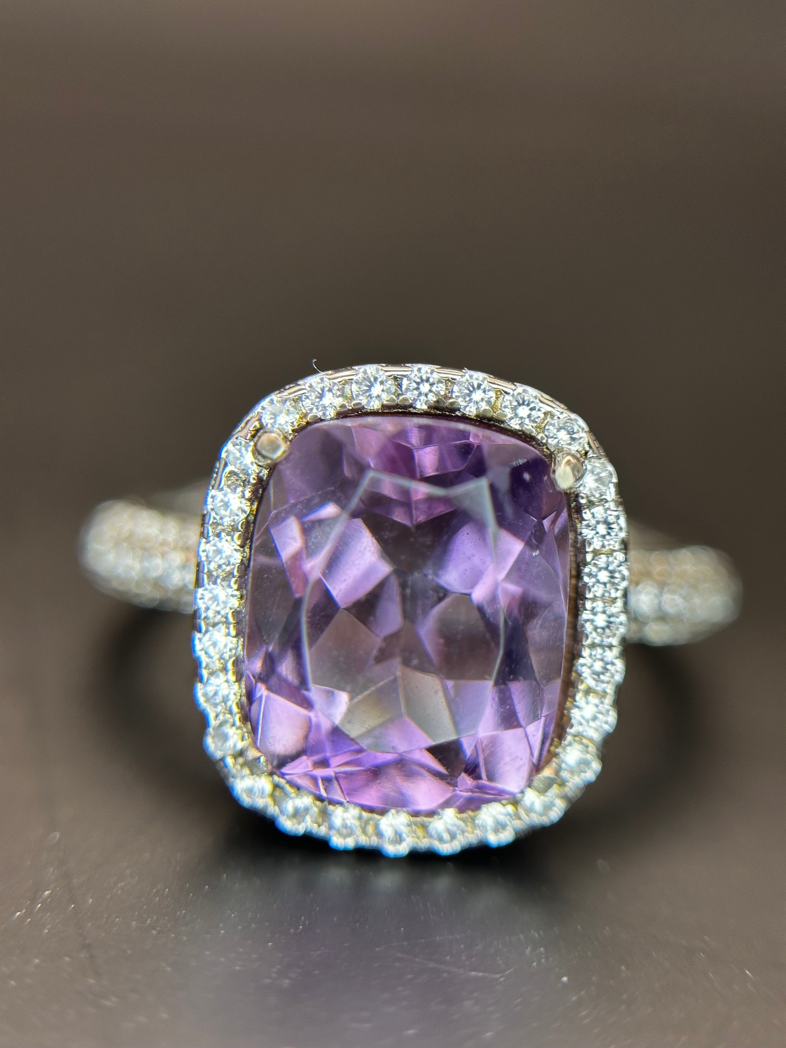 Shiza Gems cushion-cut amethyst ring with CZ halo in sterling silver. Features a soft lavender-purple center stone and sparkling pavé accents.
