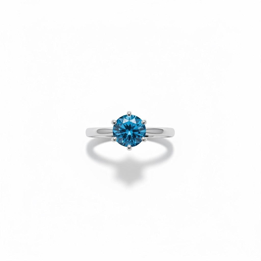 Shiza Gems blue moissanite solitaire ring in sterling silver. Round brilliant cut stone in 4-prong setting on polished band.