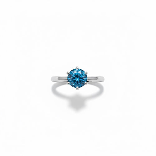 Shiza Gems blue moissanite solitaire ring in sterling silver. Round brilliant cut stone in 4-prong setting on polished band.