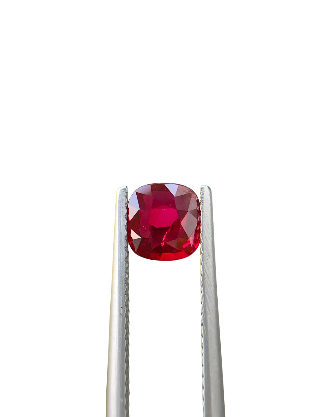 Shiza Gems 1.06 ct cushion cut vivid red unheated natural ruby gemstone held in tweezers against a black background.