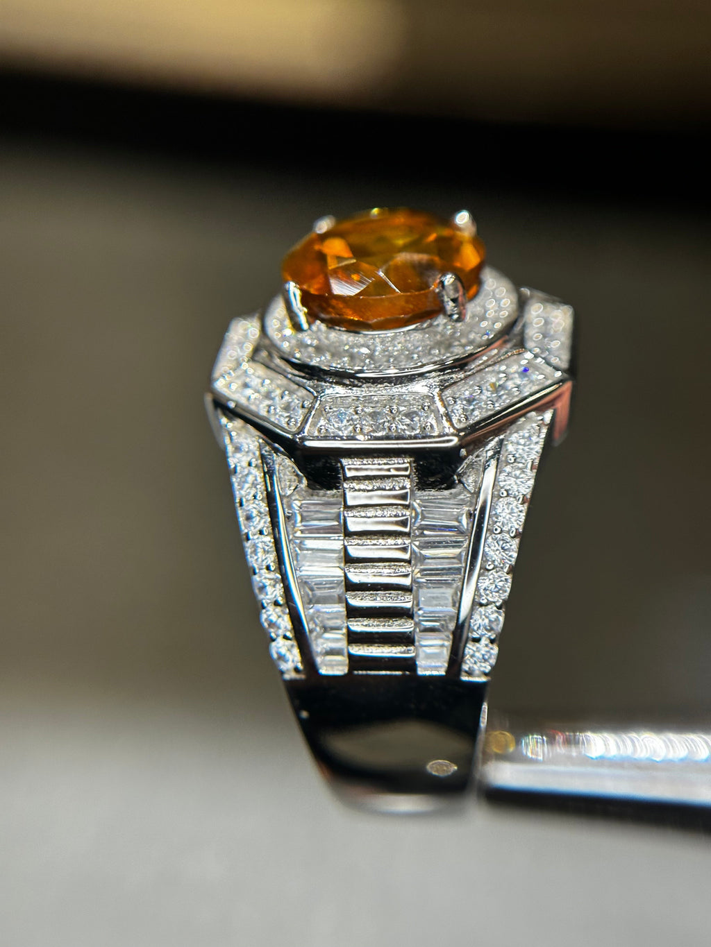 Shiza Gems men's ring with large oval golden-orange citrine center stone, surrounded by pave CZ and baguette accents in sterling silver.