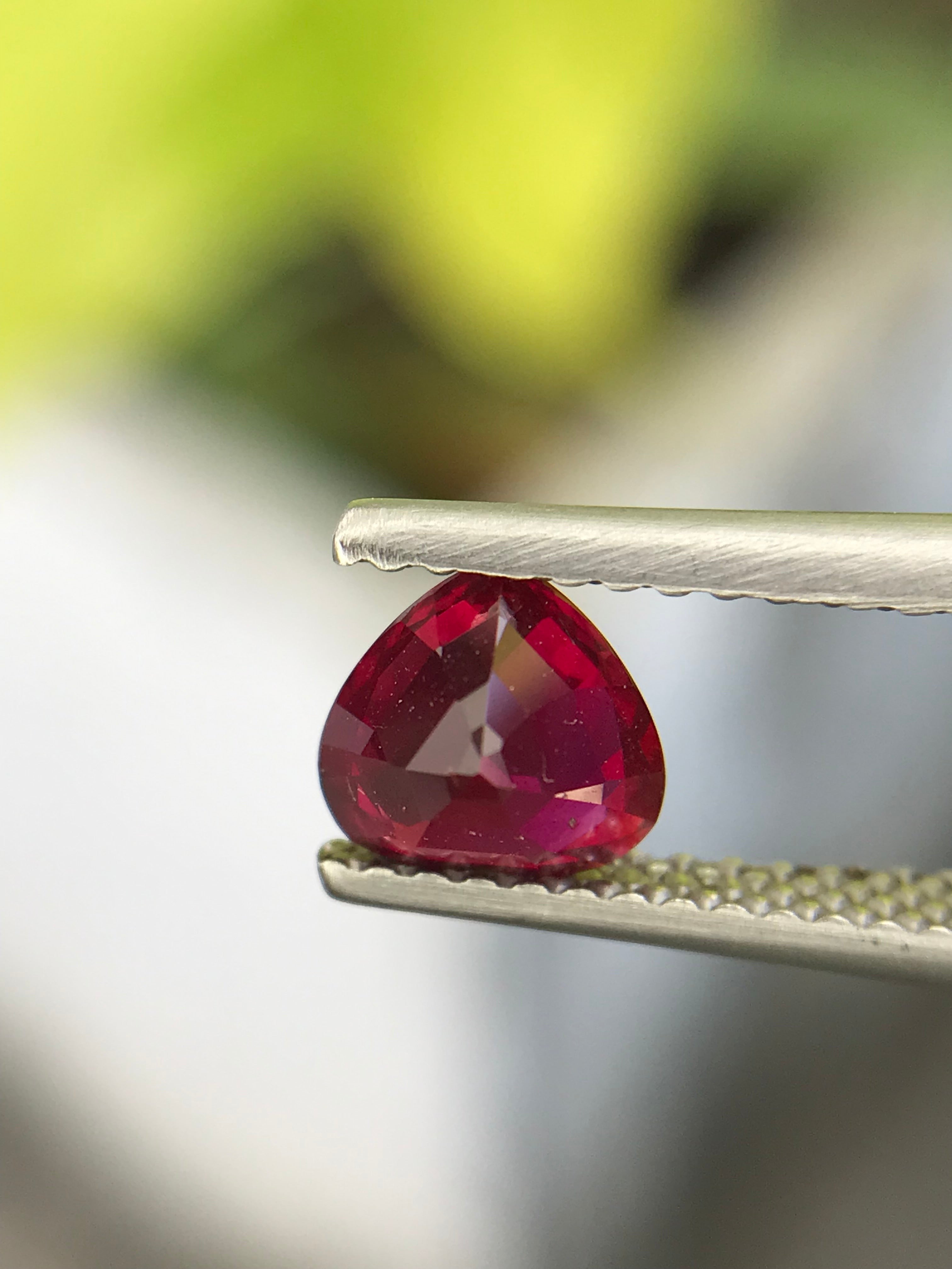 Shiza Gems 1.04 ct vivid red heart-cut unheated natural ruby from Mozambique, held by tweezers.