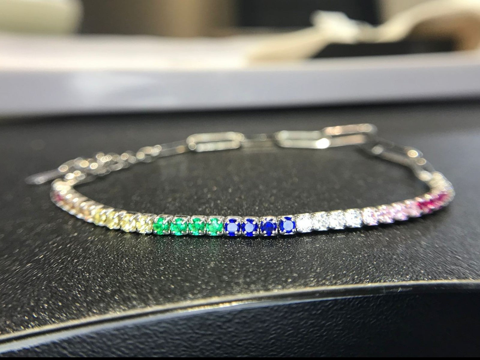 Shiza Gems rainbow multi color CZ tennis bracelet in sterling silver with yellow, green, blue, pink, and clear stones.
