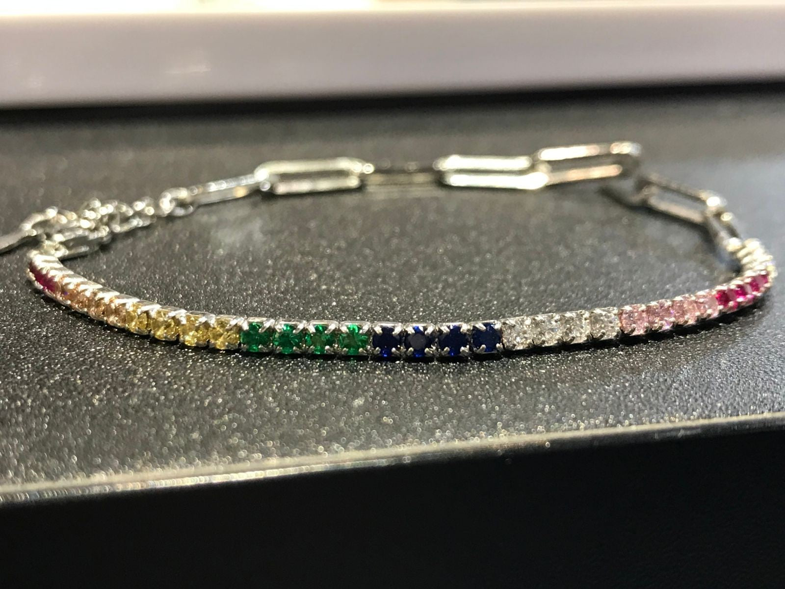Shiza Gems rainbow multi color CZ tennis bracelet in sterling silver with clear, yellow, green, blue, pink, and red stones.